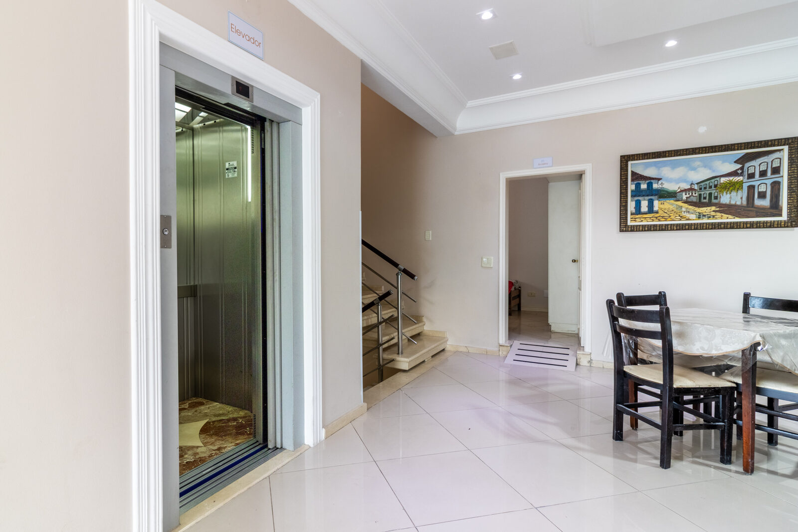 Hall interno com elevador e escada para acesso aos andares